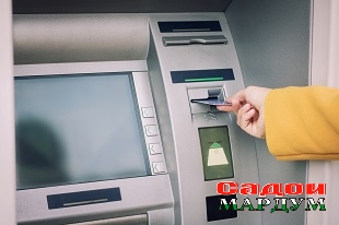 Cropped Hand Of Woman Inserting Card In Atm Machine